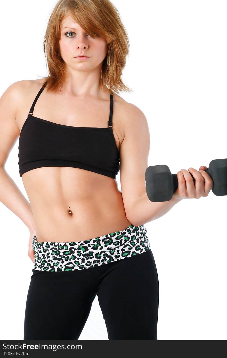 Young woman poses curling a dumbbell wearing sports bra with leggings. Young woman poses curling a dumbbell wearing sports bra with leggings.