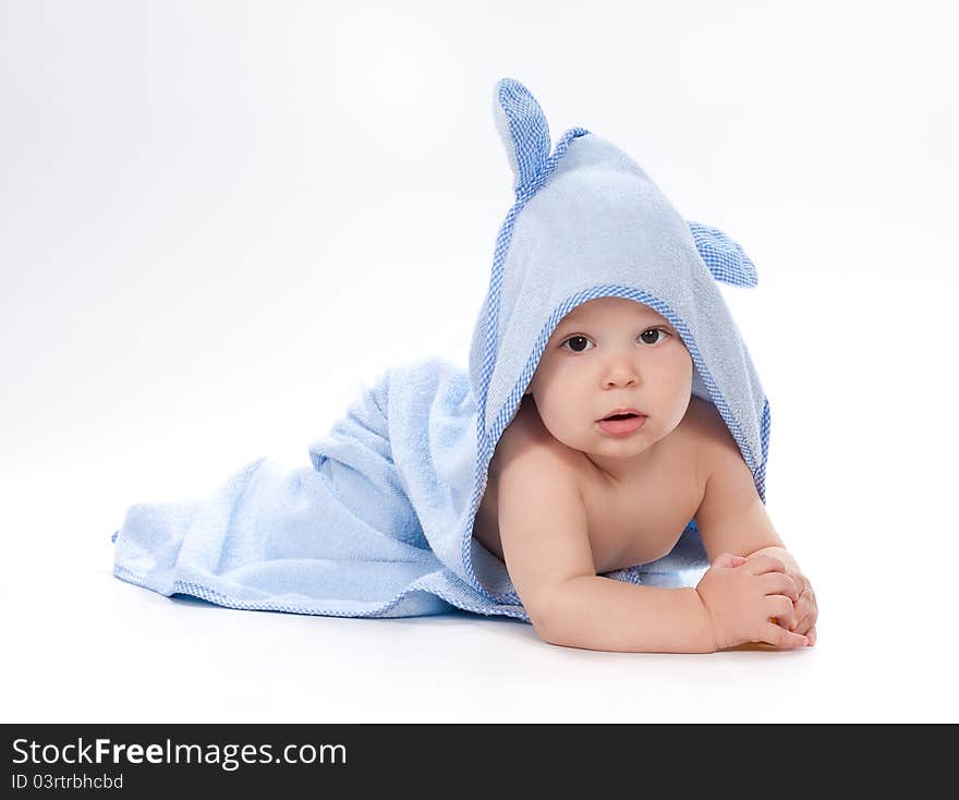 Baby under blue towel on white background