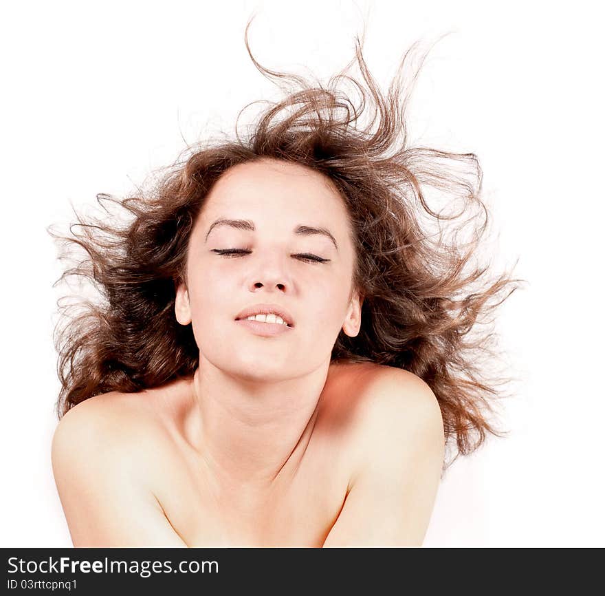 Beautiful woman with hair blown by wind on white