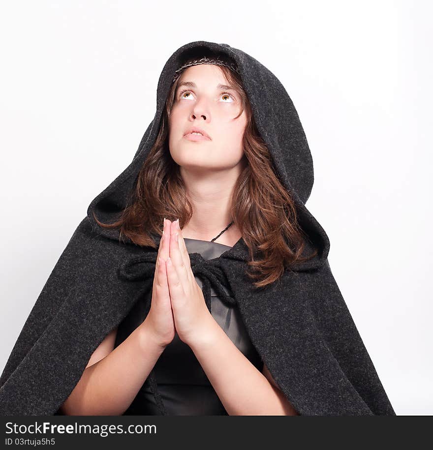 Praying woman in black hood on white background