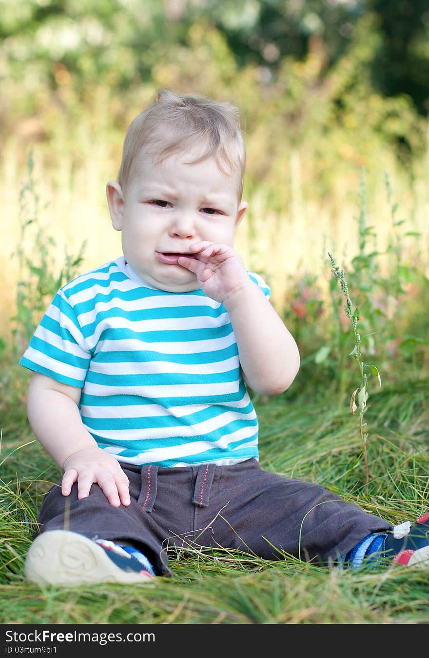 Baby sitting on grass crying