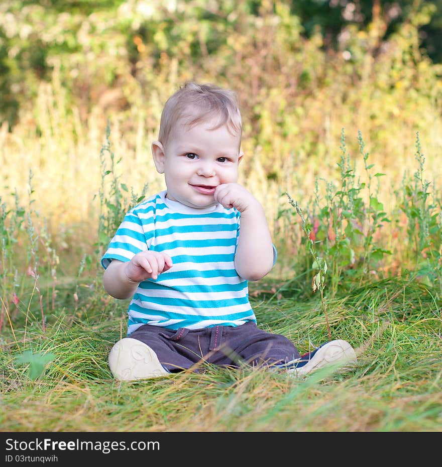 Baby sitting on grass smiling