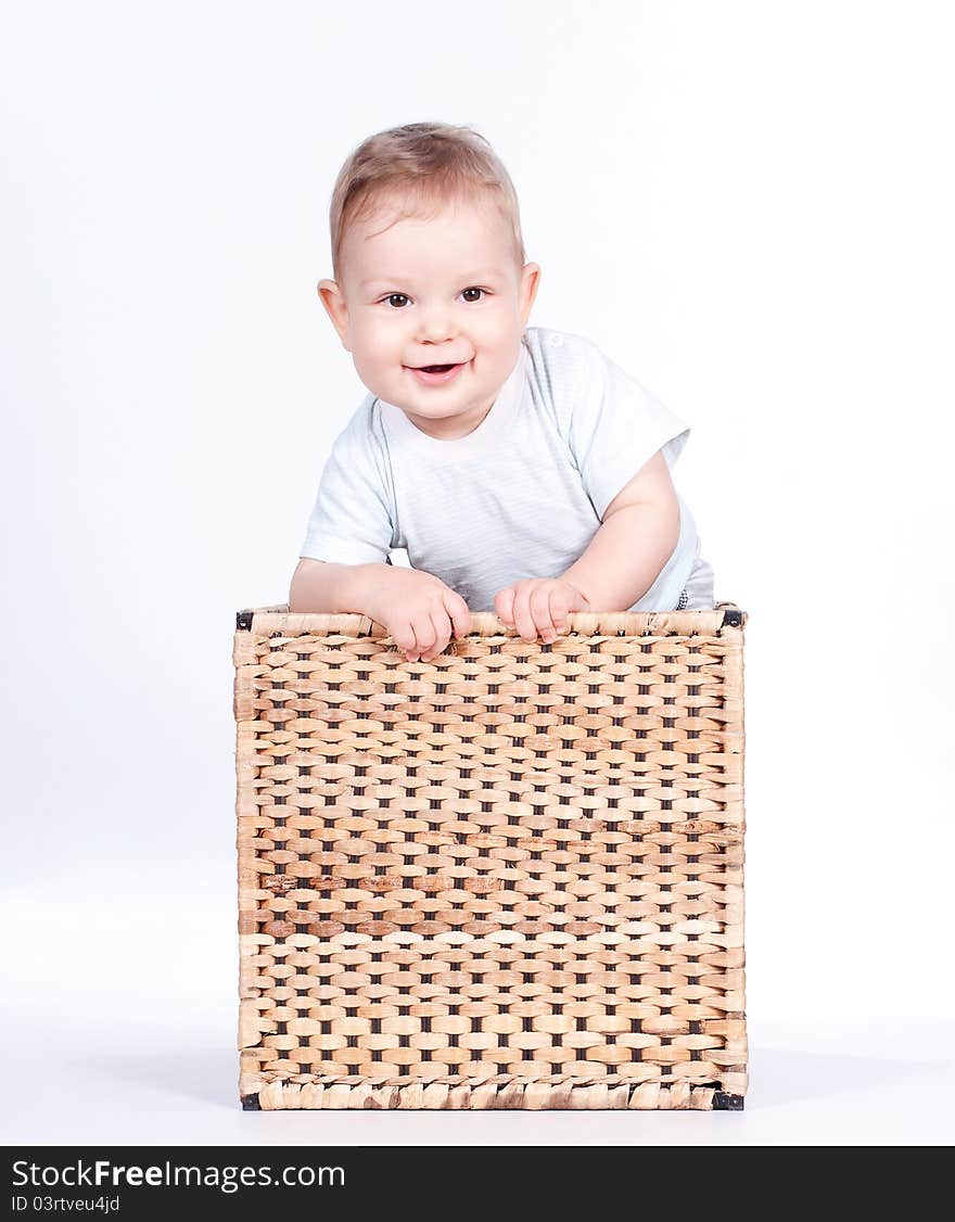 Baby boy in wicker basket on white background