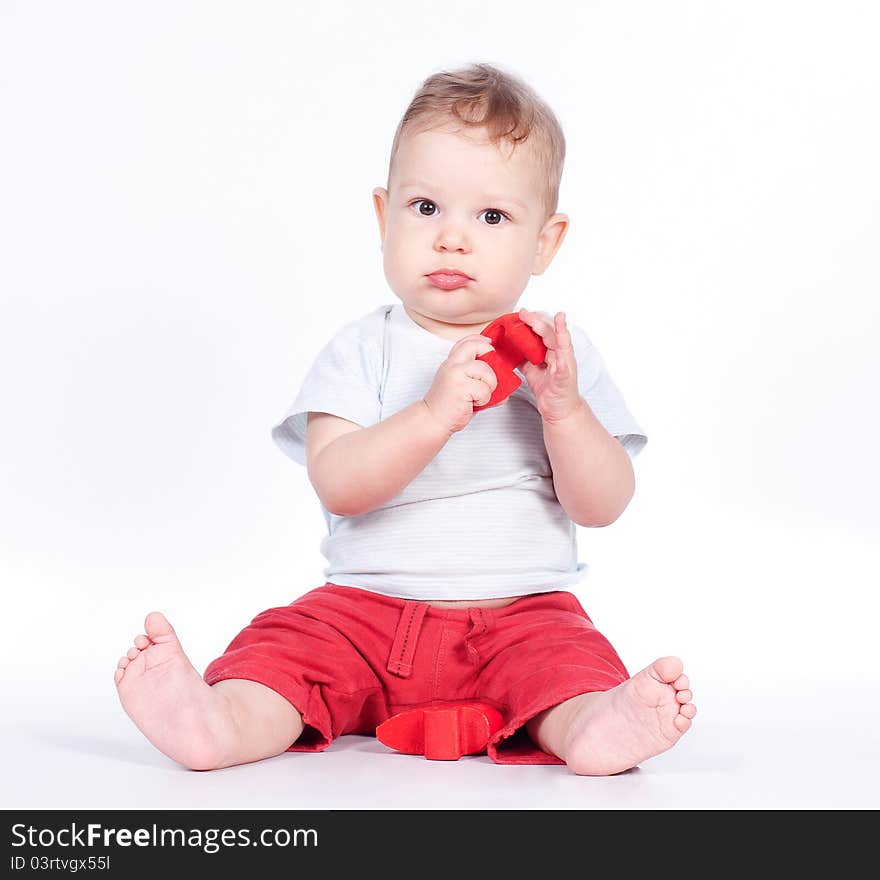 Baby playing with puzzle heart on white