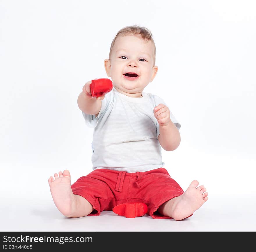 Baby playing with puzzle heart on white background