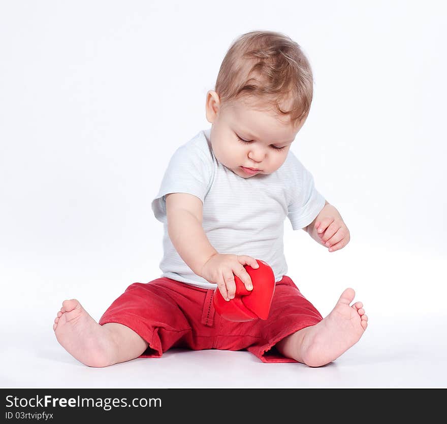 Baby playing with puzzle heart on white