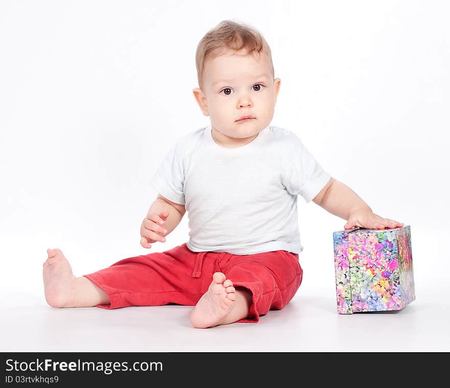 Baby boy opening gift box on white