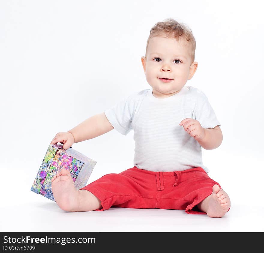 Baby boy opening gift box on white