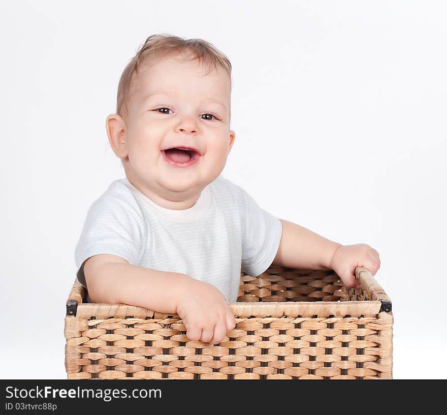 Baby boy in wicker basket on white