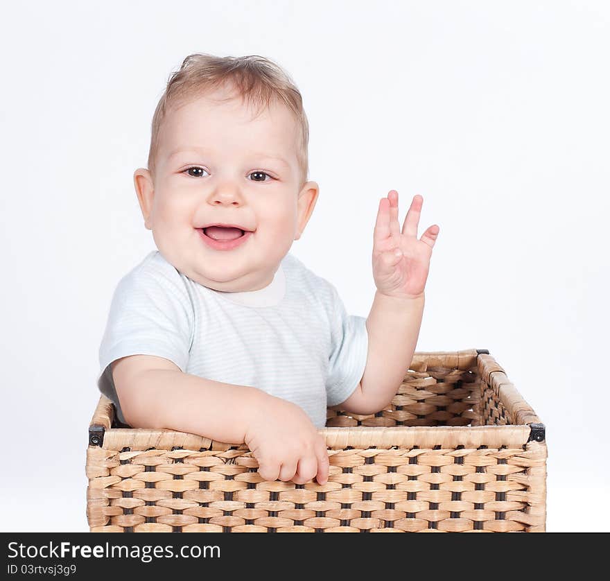 Baby boy in wicker basket on white