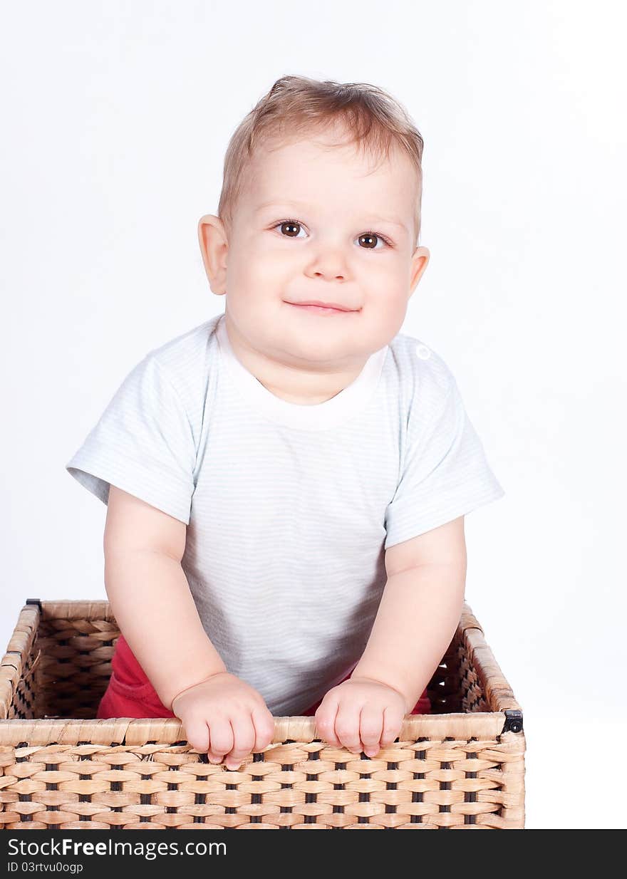 Baby boy in wicker basket on white