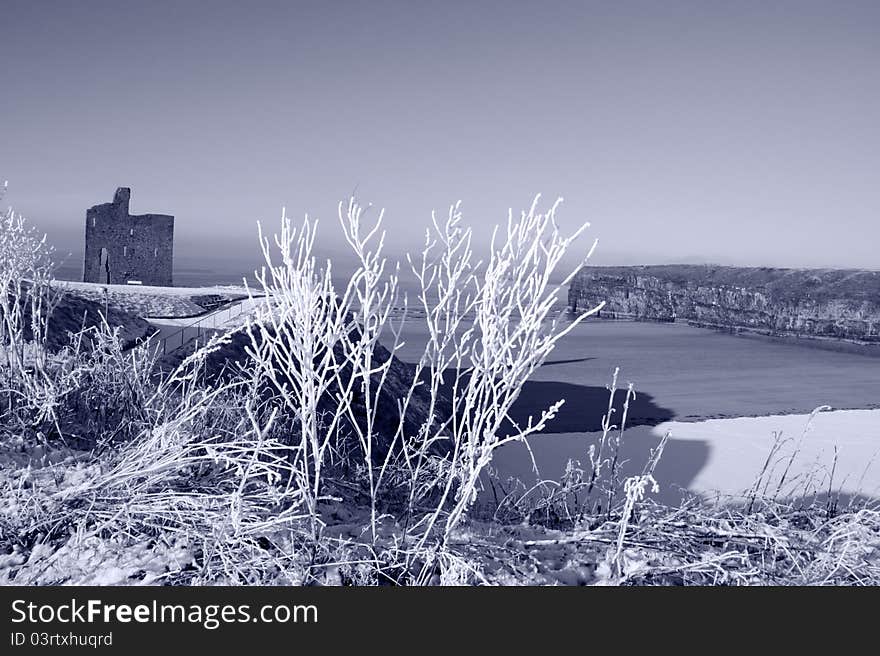 A seasonal snow covered view of atlantic ocean and ballybunion castle beach and cliffs on a frosty snow covered winters day. A seasonal snow covered view of atlantic ocean and ballybunion castle beach and cliffs on a frosty snow covered winters day