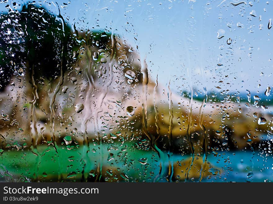 Background of sea and mountain through wet window. Background of sea and mountain through wet window