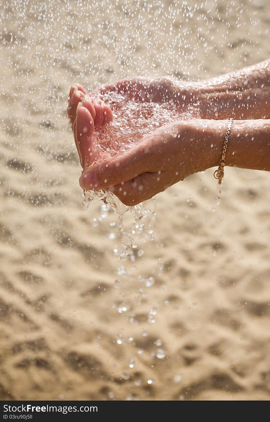 Drops of water falling into the hands. Drops of water falling into the hands