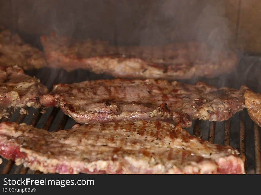 Raw meat on hot barbecue