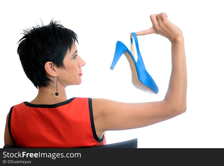 A short hair woman with a blue high heel in her right hand. A short hair woman with a blue high heel in her right hand