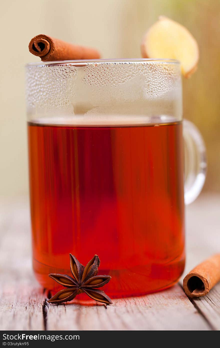 Red tea with cinnamon sticks on rustic wood