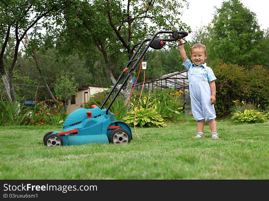 Little Boy Gardener mowing the lawn