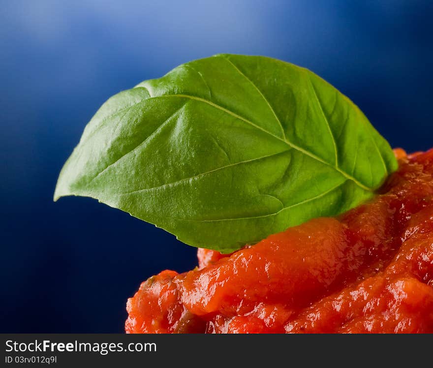 Tomato sauce with basil leaf background