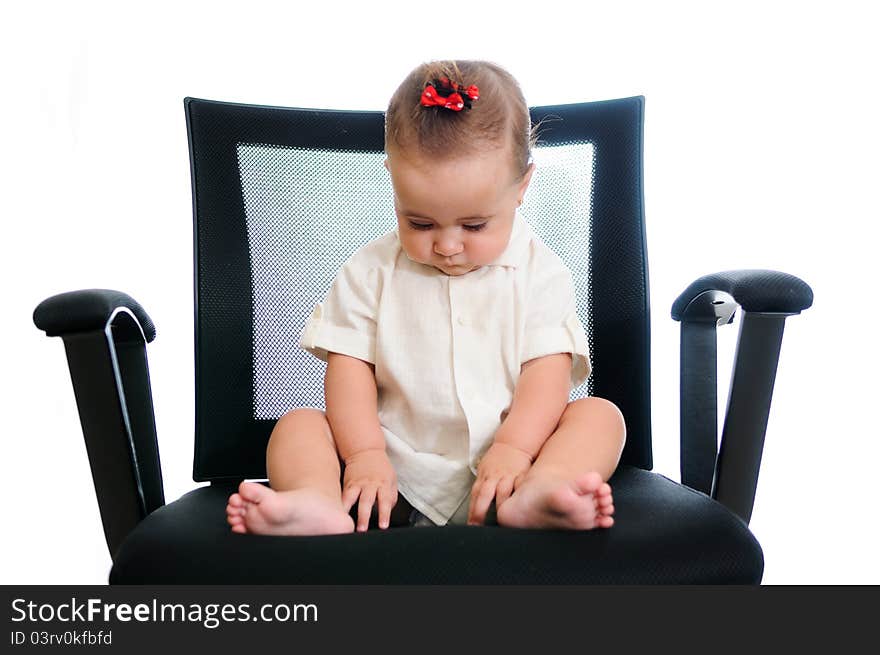 A smiling baby girl sitting in an office chair, wearing a white shirt. isolated in white. A smiling baby girl sitting in an office chair, wearing a white shirt. isolated in white