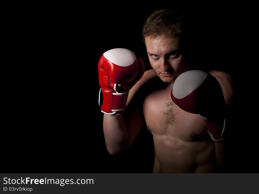 Young Boxer fighter over black background. Young Boxer fighter over black background