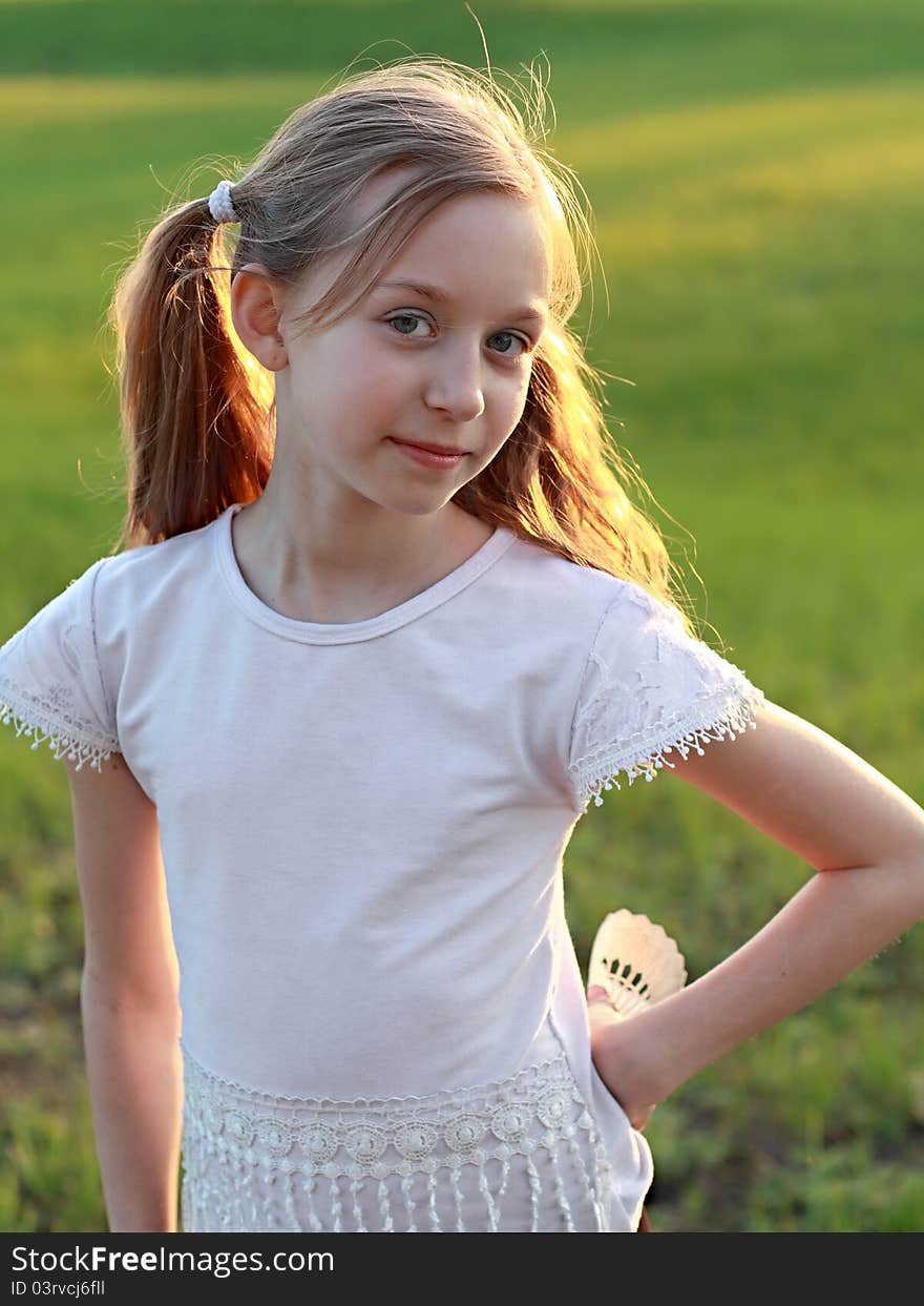 Girl on a background of grass in the rays of evening sun. Girl on a background of grass in the rays of evening sun.