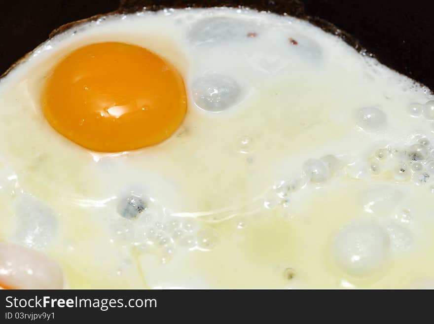 Pan full of scramble eggs in a frying pan