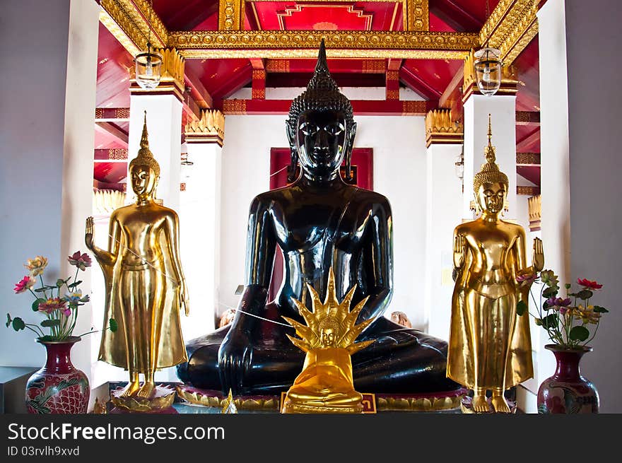 Black buddha image and three gold buddha image. Black buddha image and three gold buddha image