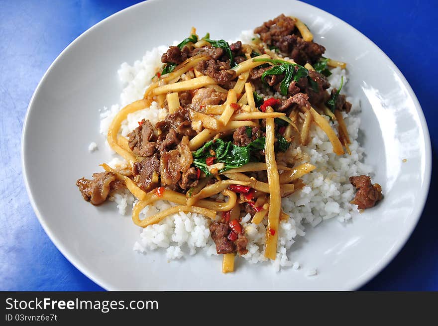 Rice topped with stir fried hot and spicy pork with basil and asparagus, Thailand