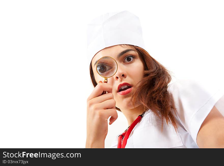 Surprised nurse doing a medical examination. She looks through a magnifying glass