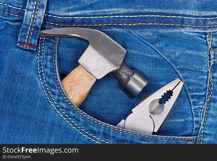 Hammer And Pliers In Pocket Jeans.