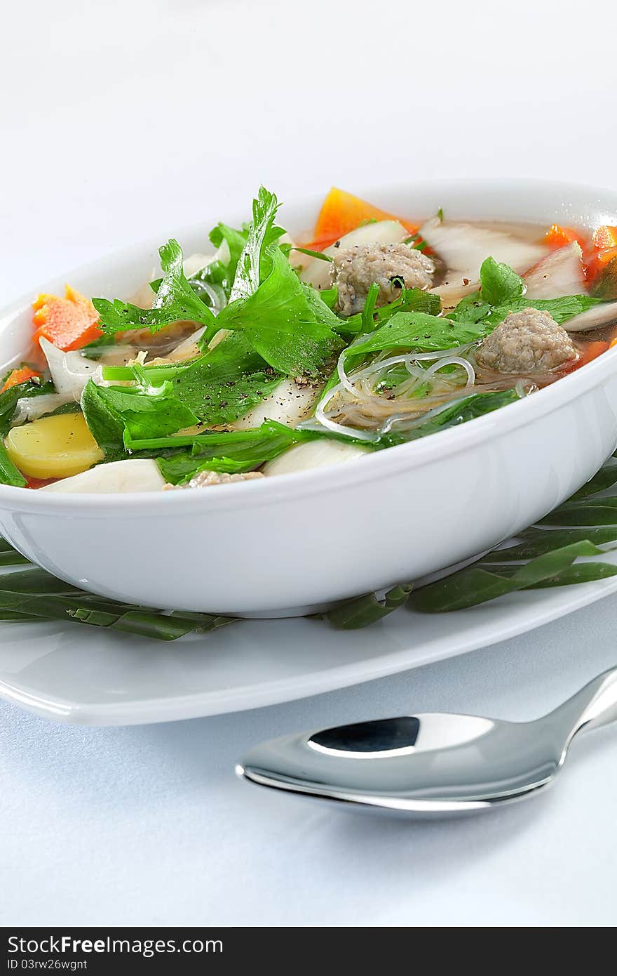 Close up view of nice soup with vegetables on white back. Close up view of nice soup with vegetables on white back