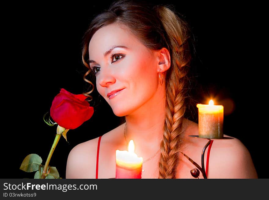 Portrait of a young pretty woman with red rose on black background. Portrait of a young pretty woman with red rose on black background