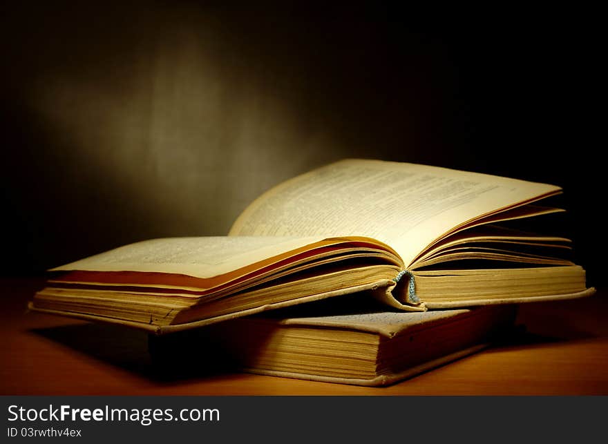 Old book on a dark background and light beam. Old book on a dark background and light beam