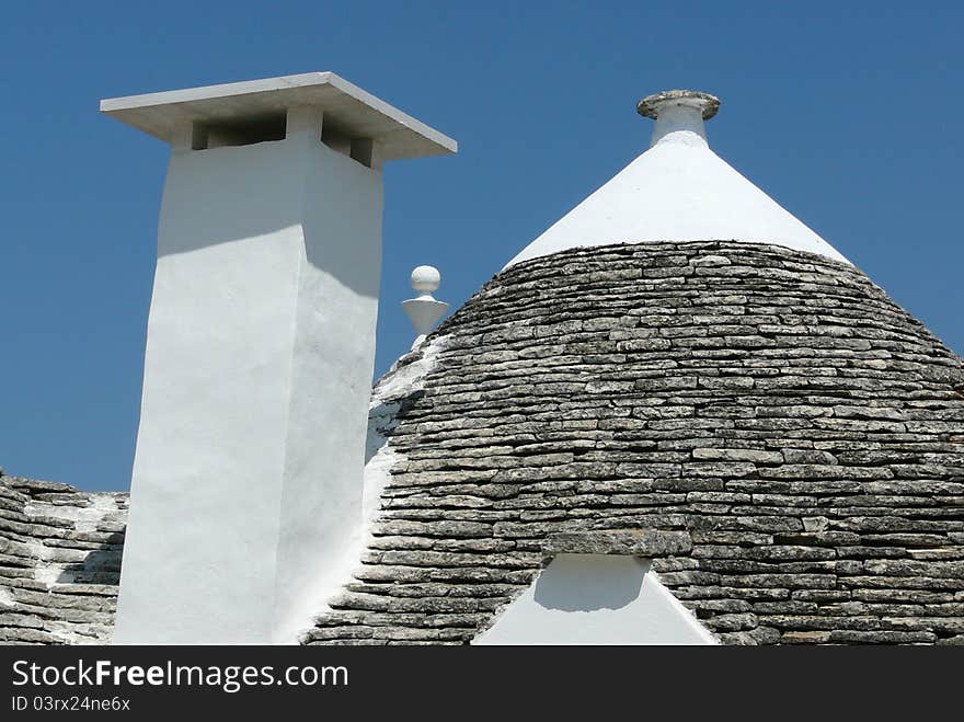 Typical conical roof and chemney of trullo in Alberobello, Italy during the summer. Typical conical roof and chemney of trullo in Alberobello, Italy during the summer