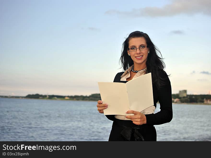 Girl holding blank paper. sea on the background