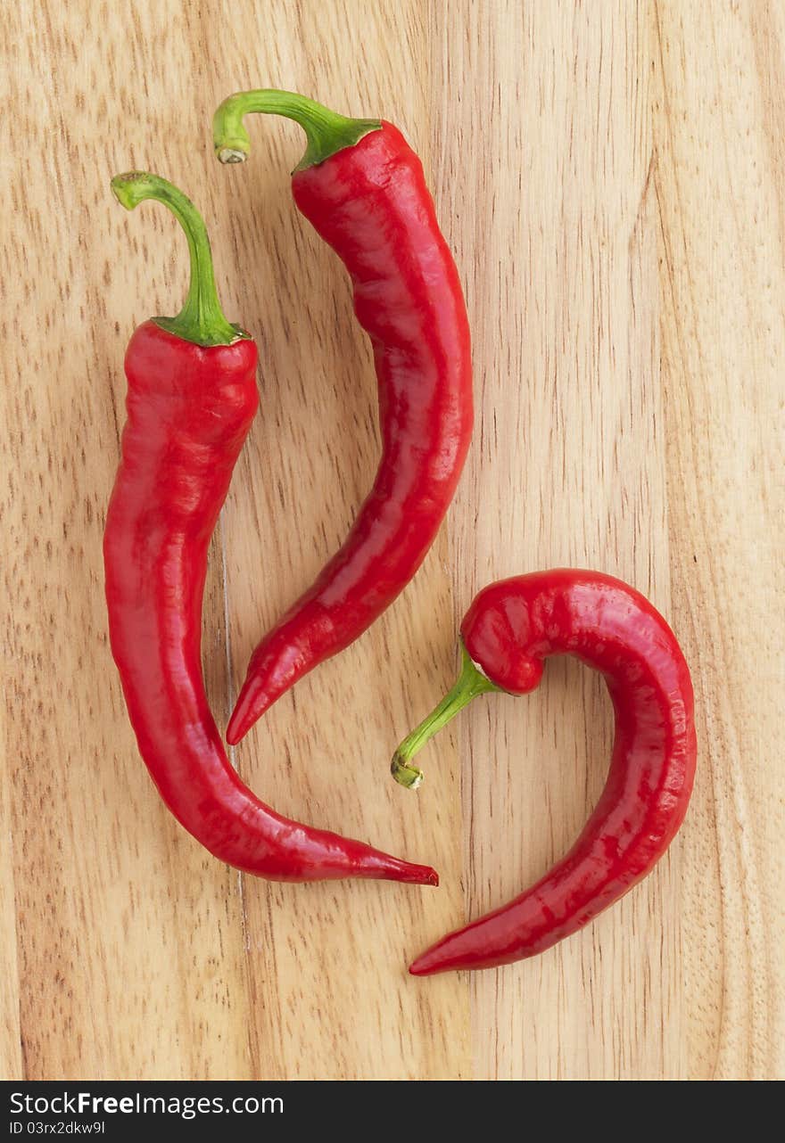 Closeup red hot peppers on wood board