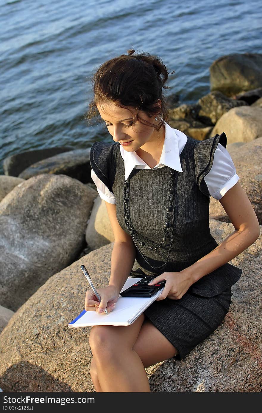 Beautiful girl with a notebook and a calculato