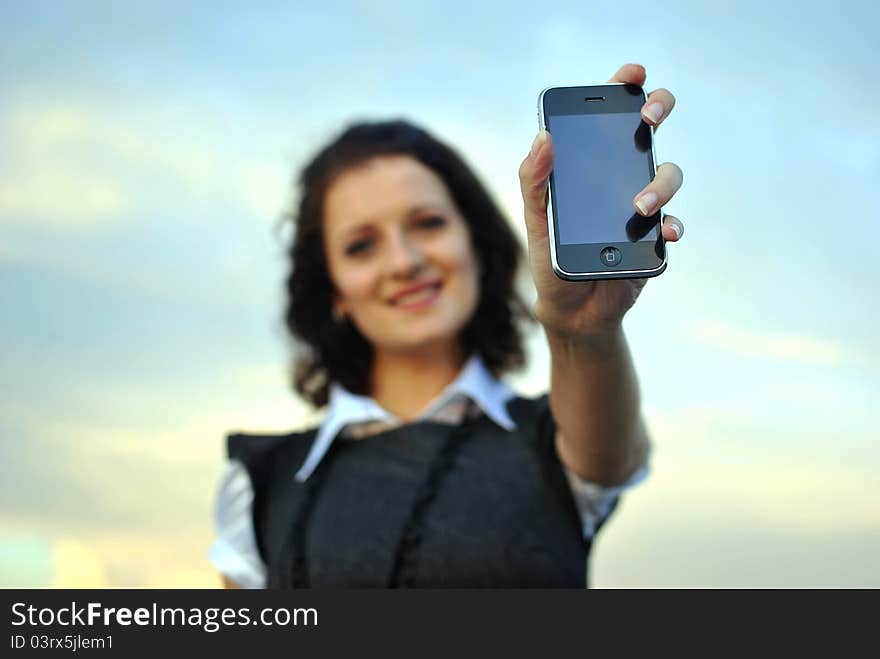 Lovely young woman showing mobile phone. focused on the phone.