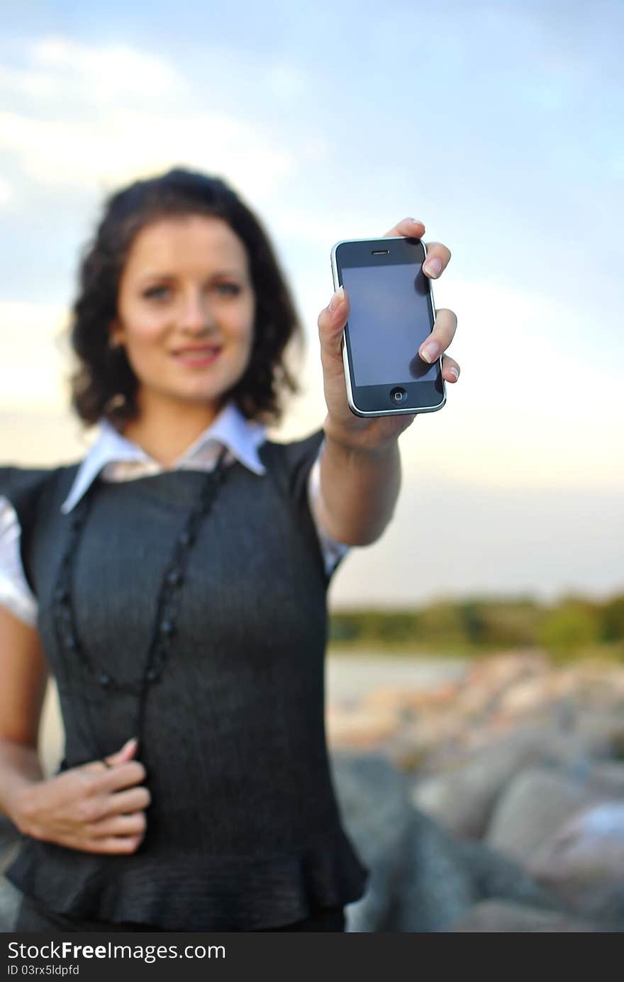 Lovely young woman showing mobile phone