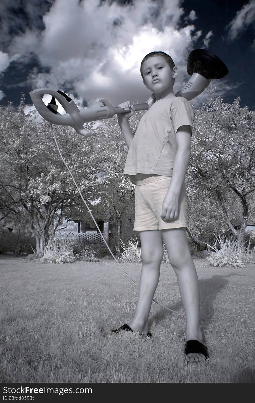 Young boy with trimmer in garden