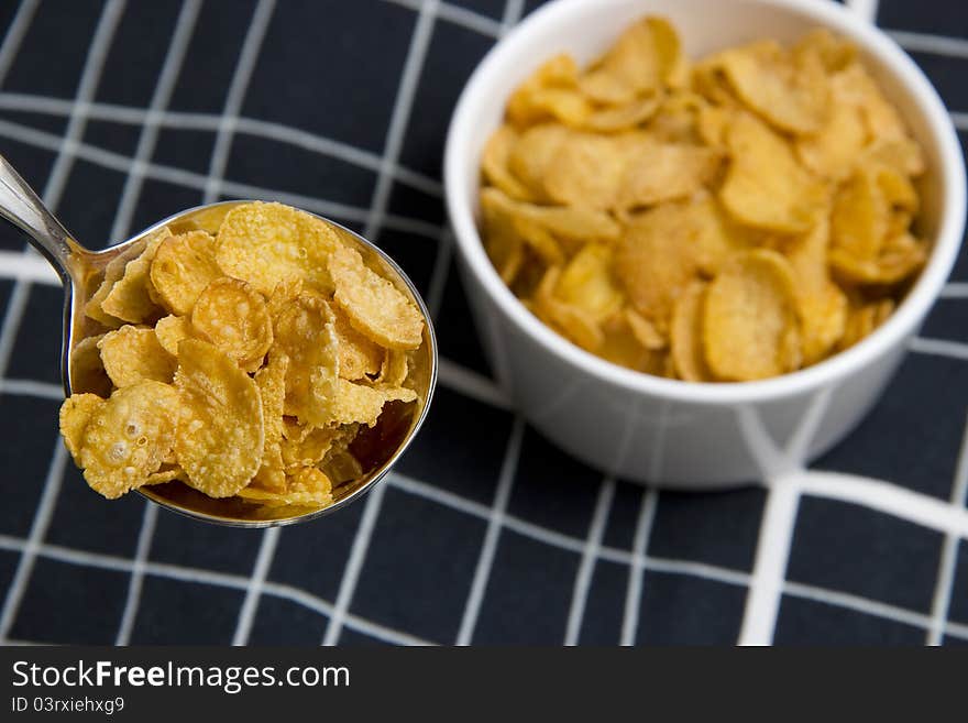 A spoonful of cereal with a bowl of background. A spoonful of cereal with a bowl of background