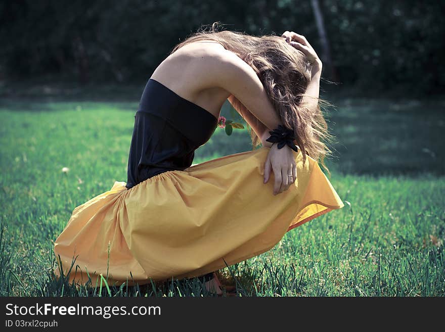 Beautiful young woman sitting on the grass,
she has flowers on her dress and she looks like a flower itself. Beautiful young woman sitting on the grass,
she has flowers on her dress and she looks like a flower itself.