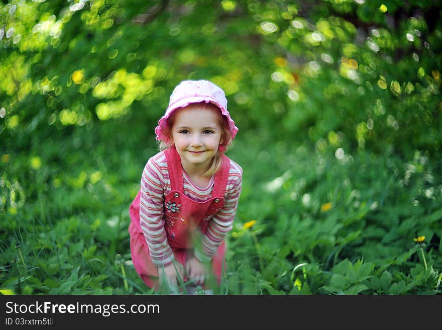 Playful little girl in hat on grass. may day