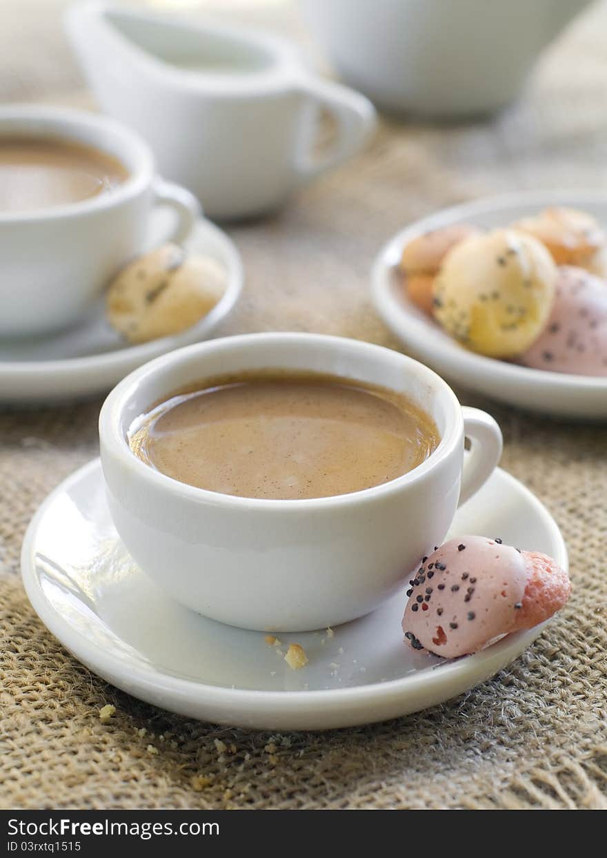 Fresh coffee with milk in cup with cookie close up. Selective focus