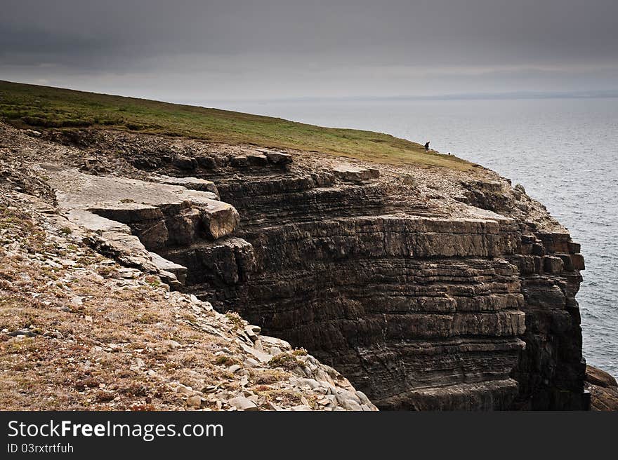 Cliffs by the sea under cloudy sky, Loop Head, Co. Clare, Ireland. Cliffs by the sea under cloudy sky, Loop Head, Co. Clare, Ireland