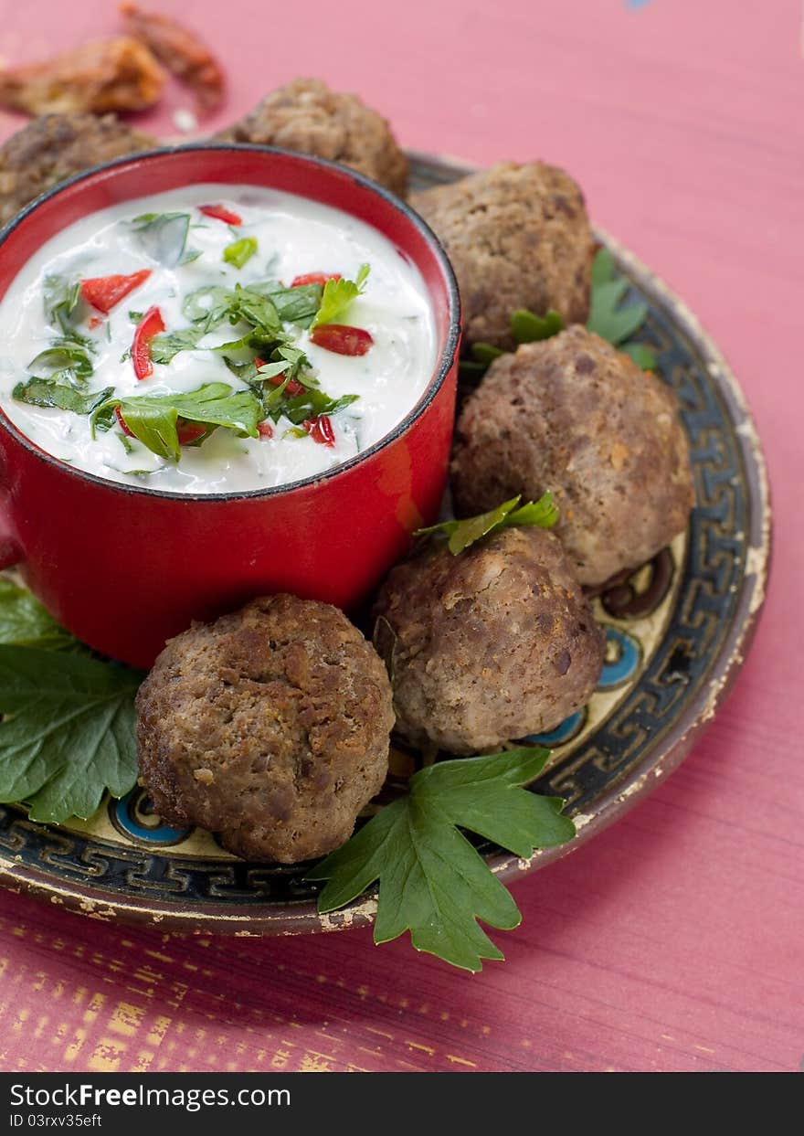 Minced meat ball with tzatziki sauce on plate. Selective focus