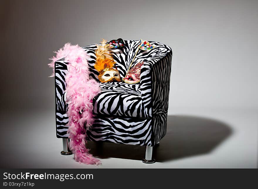 Image shoeing brightly coloured masquerade masks on retro style chair. Image shoeing brightly coloured masquerade masks on retro style chair