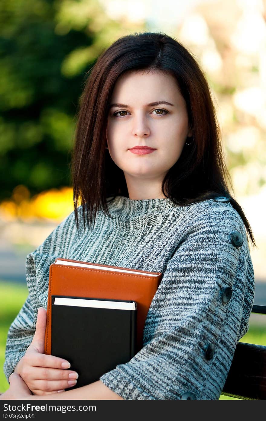 Portrait of a young female student with books at the campus