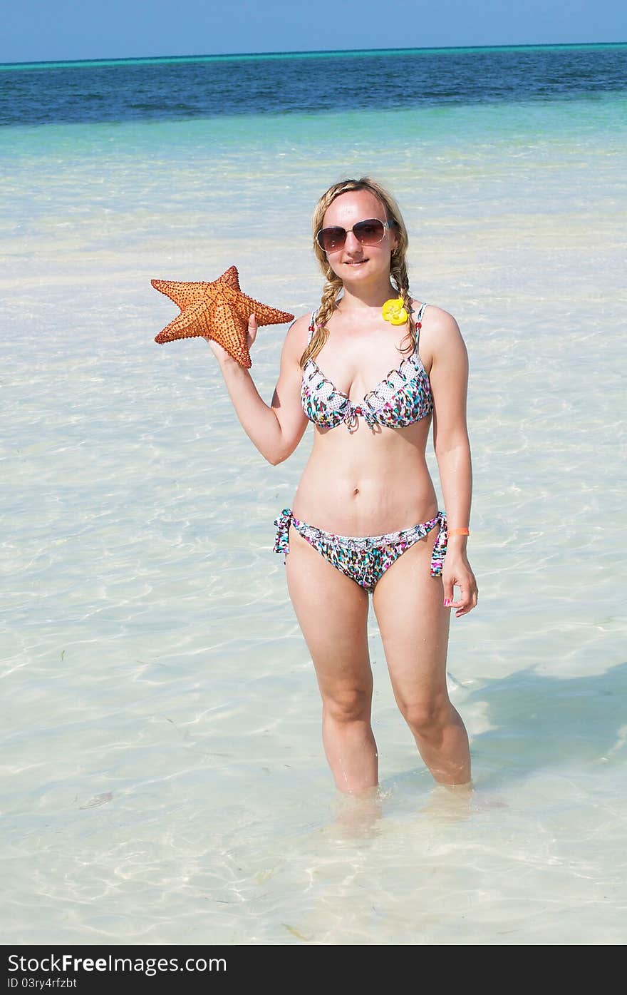 A young woman with a starfish in the ocean